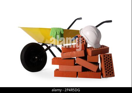 Many red bricks, wheelbarrow and construction tools on white background Stock Photo