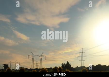 Telephone poles with cables on sunny day outdoors Stock Photo