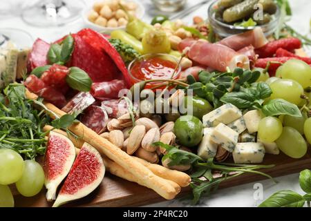 Set of different delicious appetizers on wooden board, closeup Stock Photo