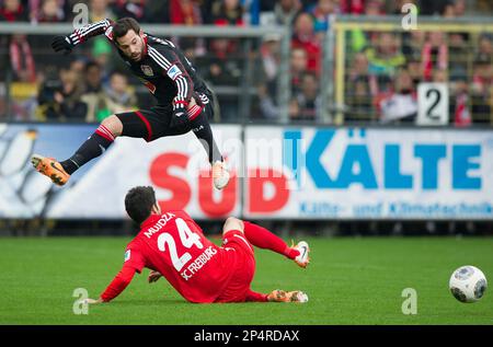 Leverkusen's Gonzalo Castro, top, vies for the ball with Freiburg's Mensur Mujdza during the Bundesliga soccer match between SC Freiburg and Bayer Leverkusen at Mage-Solar-Stadion in Freiburg, Germany, Saturday Jan. 25, 2014. (AP Photo/dpa, Uwe Anspach)