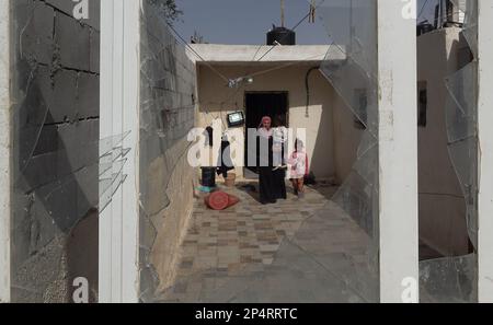 TURMUS AYYA, ISRAEL - MARCH 5: A Palestinian woman walks with her daughters at her house which is repeatedly targeted by Jewish settlers in the outskirts of the Palestinian town of Turmus Ayya located near the Israeli settlement of Shilo in the Ramallah and al-Bireh Governorate on March 5, 2023 in the West Bank, Israel. Israel had notified the Biden administration it would hold off on legalizing additional outposts in the West Bank for several months, but that it would still be moving forward with the legalization of the nine West Bank outposts and the approval to build hundreds of housing uni Stock Photo