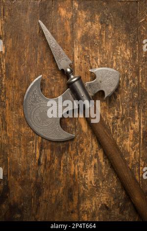 Medieval battle axe with wooden handle and steel blade with Spanish engravings Stock Photo