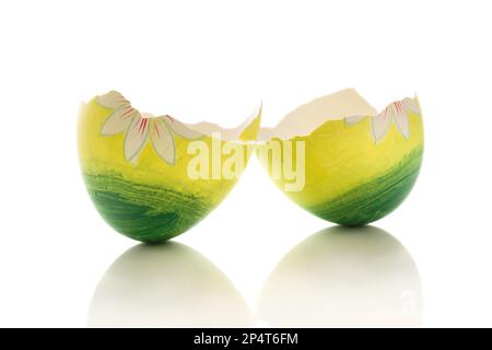 Two halves of a broken green easter egg on a white background Stock Photo