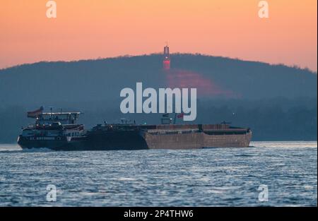 Sunset at the river Rhine near Duisburg looking towards the spoil tip Rheinpreussen with its mine lamp Stock Photo