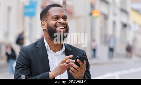 African American bearded man with smartphone navigation application looking for address using online map app in mobile phone. Ethnic male professional Stock Photo