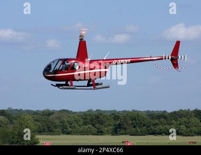 A Robinson R44 Raven II helicopter arrives a Redhill Aerodrome Surrey UK Stock Photo