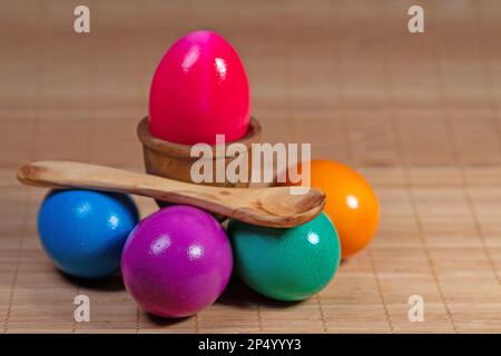 Colorful chicken eggs, wooden spoons and egg cups Stock Photo