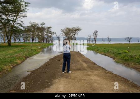 Young female tourist on safari standing outside with lake nakuru in the background in kenya Stock Photo