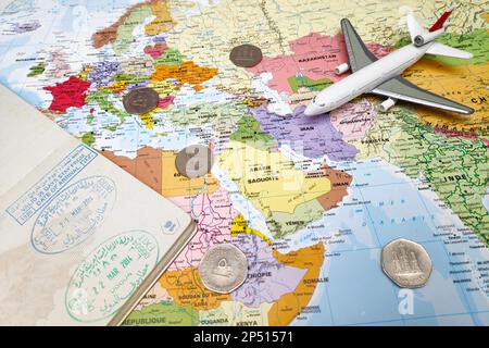 Dubai, UAE - February 19 2018: Composition made of a world map focused on Middle East with on it, some UAE dirham coins as well as an opened passport Stock Photo