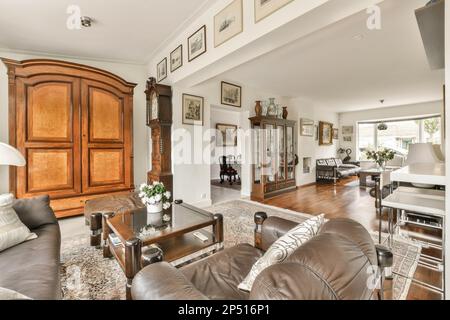Amsterdam, Netherlands - 10 April, 2021: a living room with brown leather couches and coffee table in the center of the room is an open doorway Stock Photo