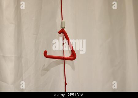 Triangular red emergency pull cord against neutral background with copy space Stock Photo