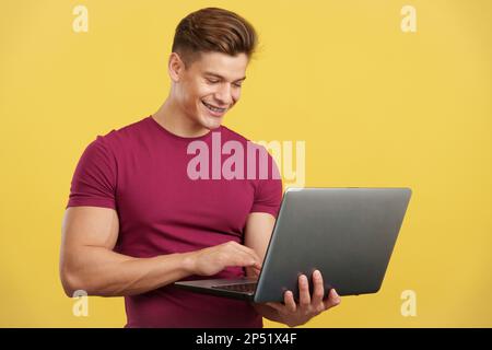 Strong and happy man using a laptop and smiling Stock Photo