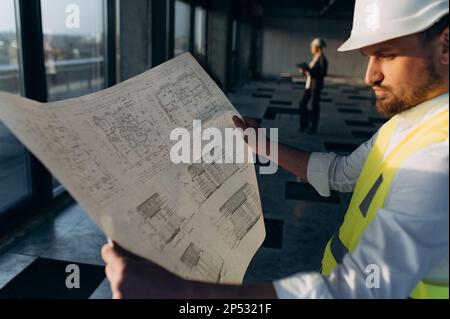 male engineer working on an architectural project at a construction site in the office. Stock Photo