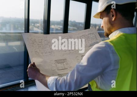 male engineer working on an architectural project at a construction site in the office. Stock Photo