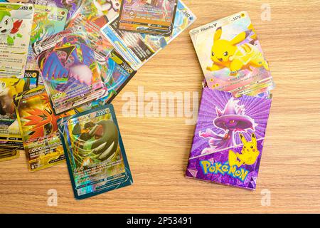 Arahal. Seville. Spain. 1st March 2023. Collectible Pokemon cards placed on a wooden table. Collectible trading cards based on the Pokemon children's Stock Photo