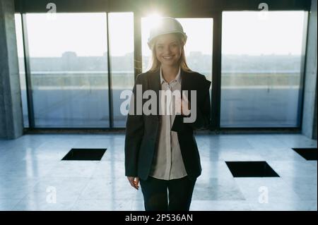 beautiful female engineer in a protective white helmet in the office. Stock Photo