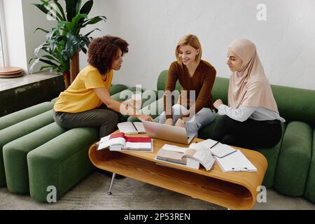 Three young multicultural businesswomen warking as a team in office. Stock Photo