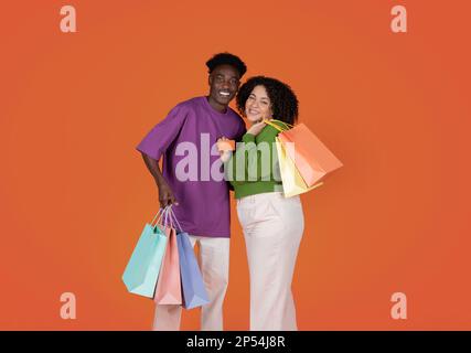 Cute young multiethnic couple with shopping bags and credit card Stock Photo