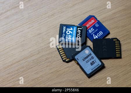 Close-up of a group of SD type memory cards on a wooden table with copy space of various brands and capacities Stock Photo