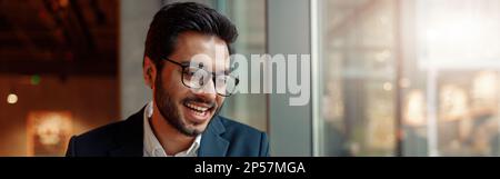 Indian businessman is making notes in notepad during working day in cafe. Blurred background Stock Photo