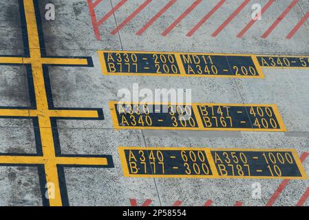 Cape Town, South Africa. 2023. Airport hatching lines with aircraft types and numbers painted on the aircraft parking zone. Stock Photo