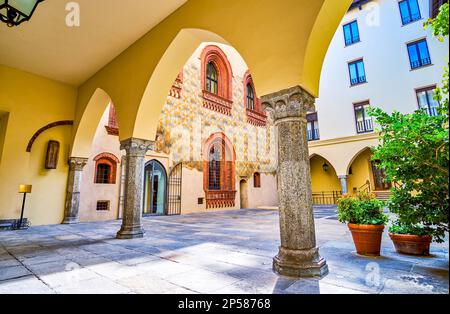 The arcades of the historic Palazzo Borromeo, leading the inner courtyard with medieval frescoes, Milan, Italy Stock Photo