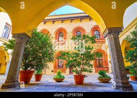 The view through the arcades of Palazzo Borromeo on the medieval frescoes on the inner wall of the palace in Milan, Italy Stock Photo