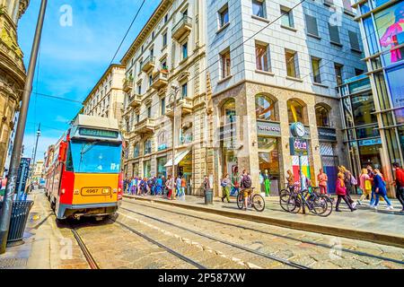 MILAN, ITALY - APRIL 11, 2022: The yellow tram rides along Via Torino street, one of the busiest in central district, on April 11 in Milan, Italy Stock Photo