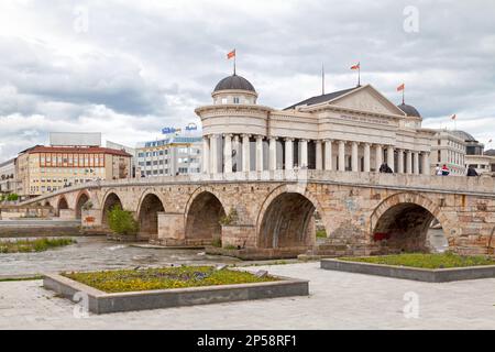 Skopje, North Macedonia - May 21 2019: Stone Bridge opposite the the Archaeological Museum of Macedonia crossing the Vardar River. Stock Photo