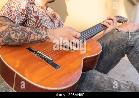 Anonymous street musician playing guitar in the street Stock Photo
