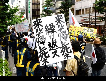 Japanese extremists, holding national and imperial flags, march