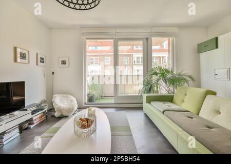 a living room with couches and a flat screen tv on the wall in front of the sofa is green Stock Photo