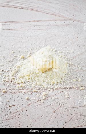 Slice of Parmigiano Reggiano, an Italian grated cheese on a marble base. Stock Photo