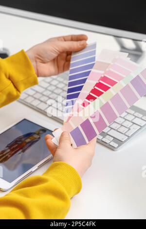 Female tailor with color palettes at table, closeup Stock Photo