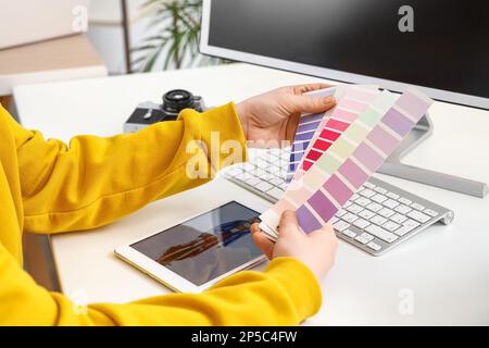 Female tailor with color palettes at table, closeup Stock Photo