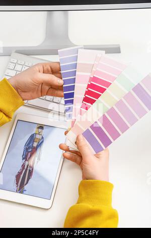 Female tailor with color palettes at table, closeup Stock Photo