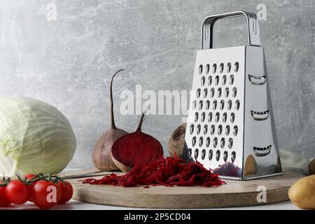Grater and fresh ripe vegetables on table Stock Photo
