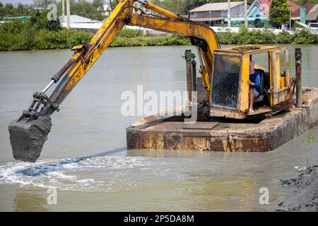 A floating dredger is dredging the bottom of the pond, Thailand Stock Photo