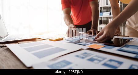 Close up ux developer and ui designer brainstorming about mobile app interface wireframe design at modern office. Creative digital development agency Stock Photo