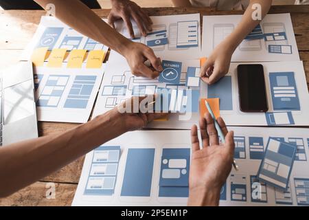 Close up ux developer and ui designer brainstorming about mobile app interface wireframe design at modern office. Creative digital development agency Stock Photo