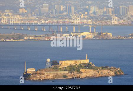 Alcatraz Island in San Francisco Bay with Bay Bridge and Oakland in background Stock Photo