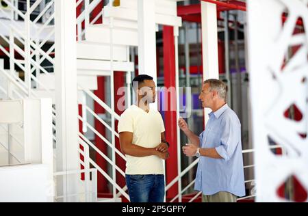 Making sure everything goes as planned. two coworkers discussing something in a casual office environment. Stock Photo