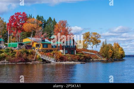 Quaint dwellings on Moosehead Lake shores. Colorful fall foliage in New England. Rockwood, Maine, US Stock Photo