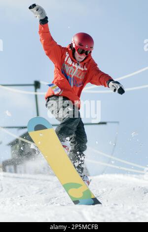 Ben Colpean, 14, of Saginaw Township lands a jump while snowboarding on the snowboard terrain park at Apple Mountain in Freeland, Mich. on Friday, Feb. 8, 2013. Overnight snow caused all area schools to close for the day giving students the chance to spend a sunny winter's day snowboarding or skiing down the hill. (AP Photo/The Saginaw News, Jeff Schrier)