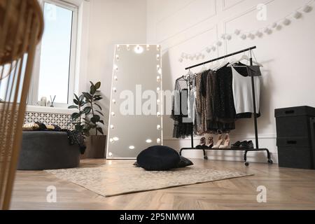 Stylish dressing room interior with trendy clothes and shoes Stock Photo