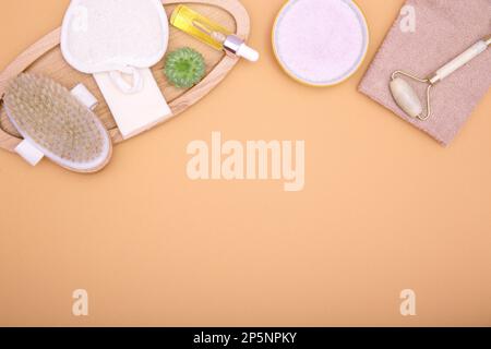 Flat lay of cosmetic products and hygiene items on an orange background. Self care concept. Beauty and spa background. copy space Stock Photo