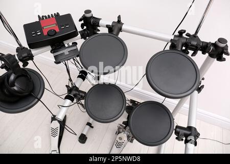 Modern electronic drum kit near white wall indoors, above view. Musical instrument Stock Photo