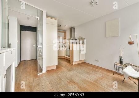 an empty living room with wood flooring and white walls in the room is well lit by the light coming through the window Stock Photo