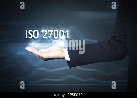 Man demonstrating at virtual icon with text ISO 27001, closeup Stock Photo