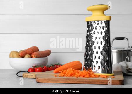 Grater and fresh ripe vegetables on table Stock Photo